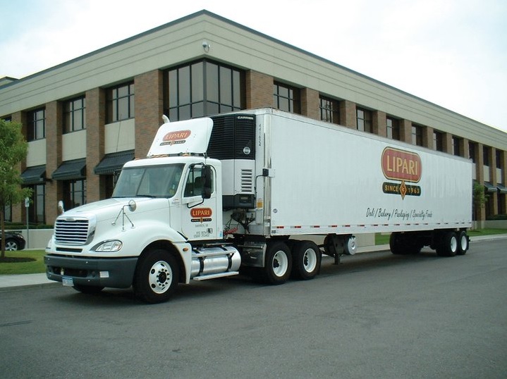 Photo of white Lipari Food truck with logo in front of a corporate building.