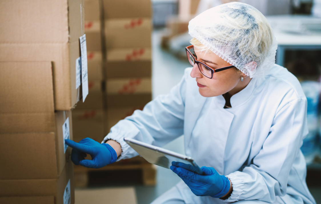 Female warehouse worker in the food and beverage industry checking product.