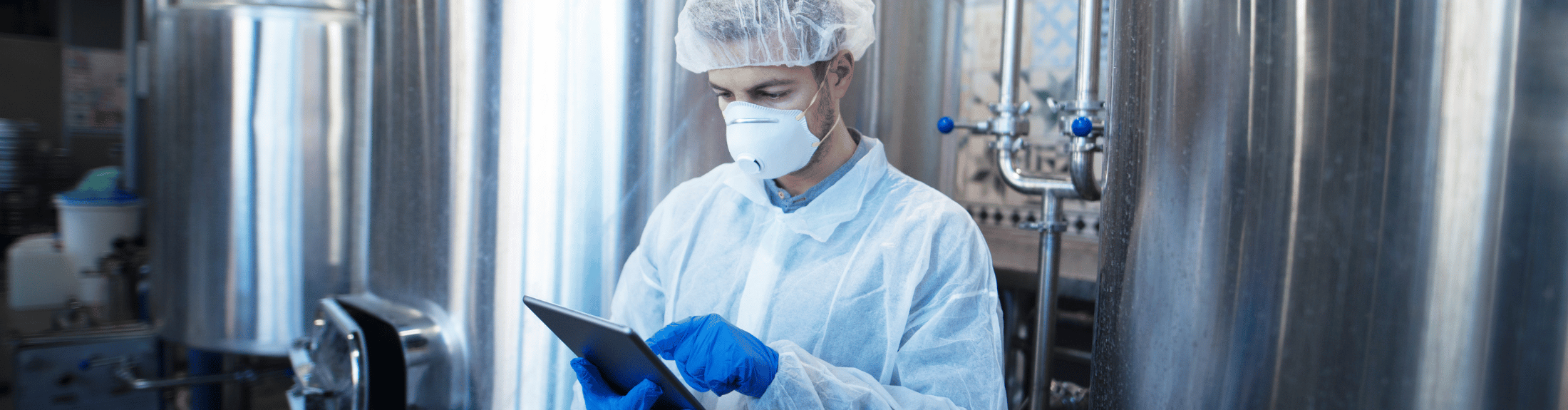 Production manager with mask and gloves managing GSFI-certified food safety management plan.