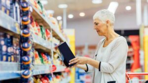 Elderly woman evaluating a food label.