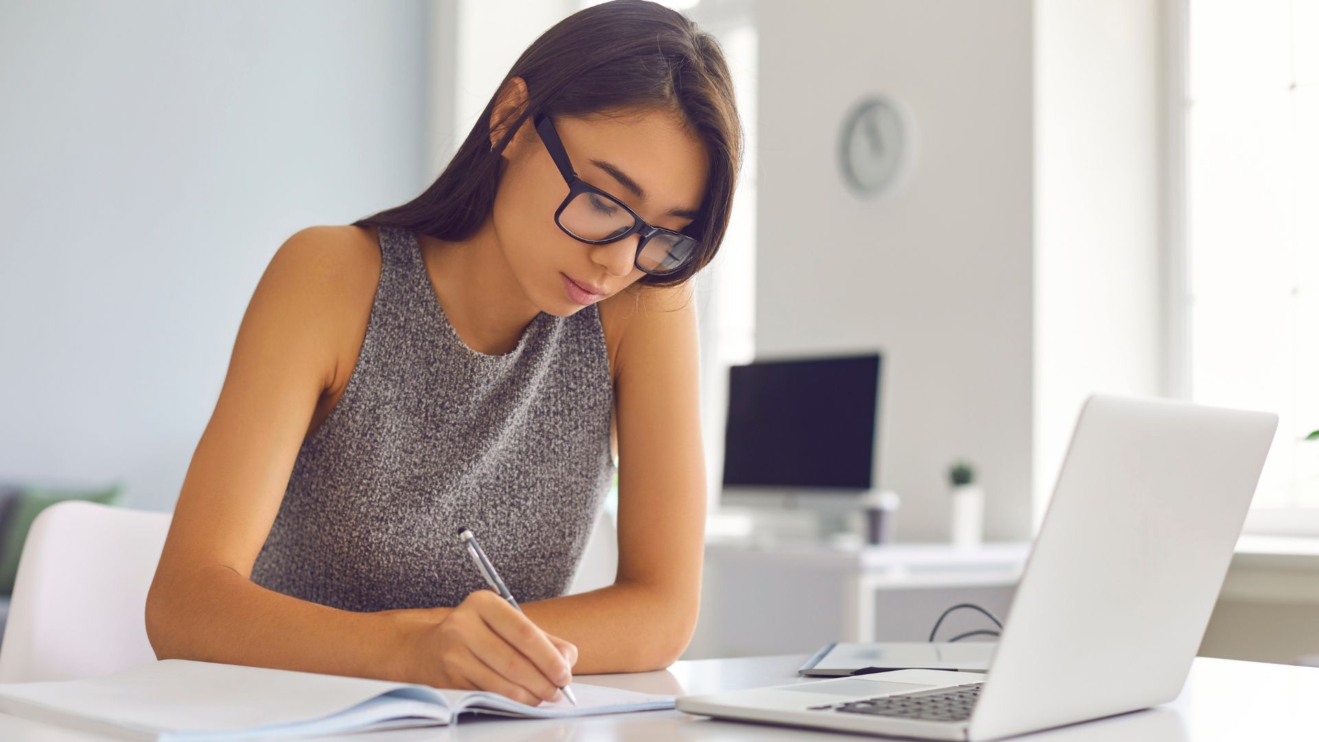 A woman sits at her desk and undergoes online Compliance Training